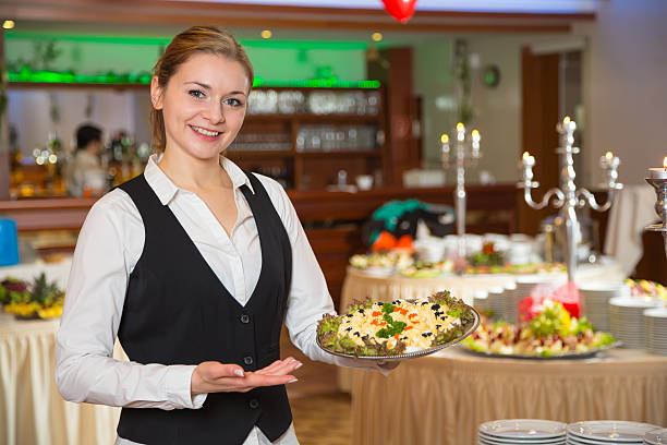 catering service employee or waitress posing with a tray of appetizers